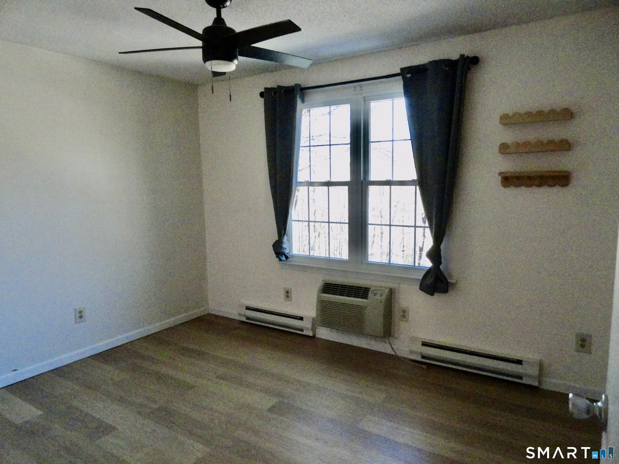 79 Hunter Court, Unit 79 Torrington, CT 06790 - Photo 15 of 19 an empty room with wooden floor and windows