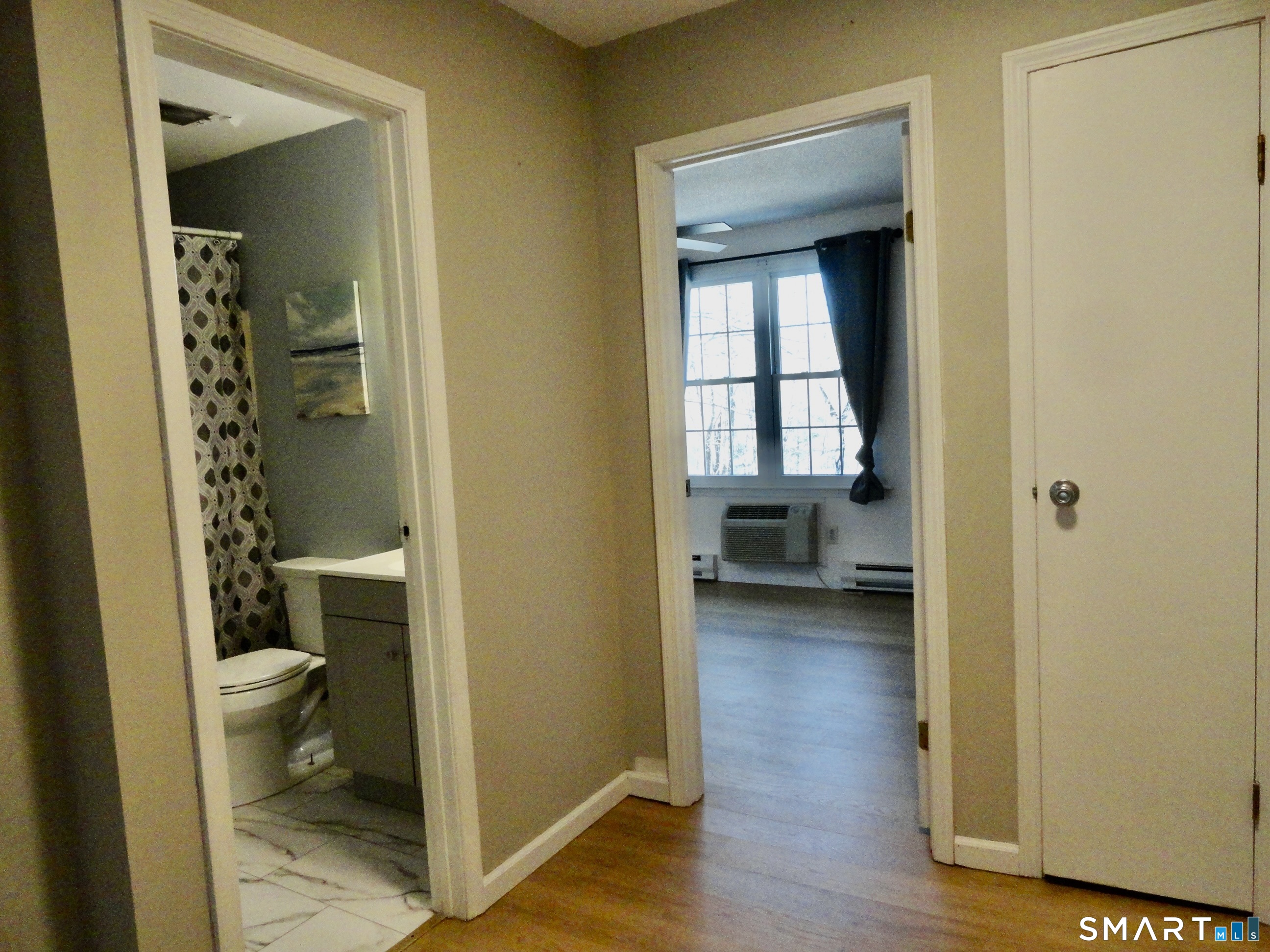 79 Hunter Court, Unit 79 Torrington, CT 06790 - Photo 17 of 19 a view of a hallway with wooden floor and a bathroom