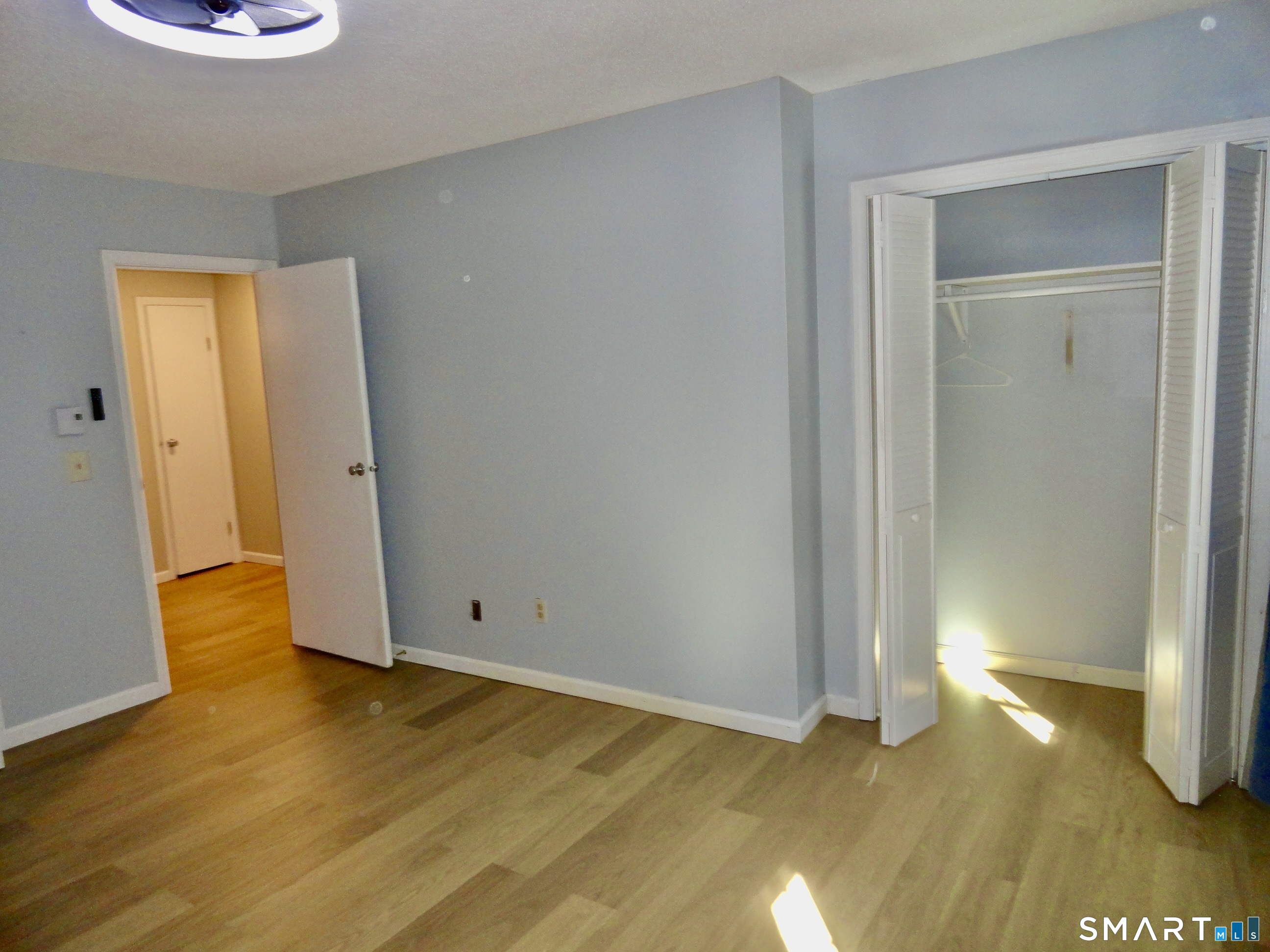 79 Hunter Court, Unit 79 Torrington, CT 06790 - Photo 10 of 19 a view of an empty room with wooden floor and a window