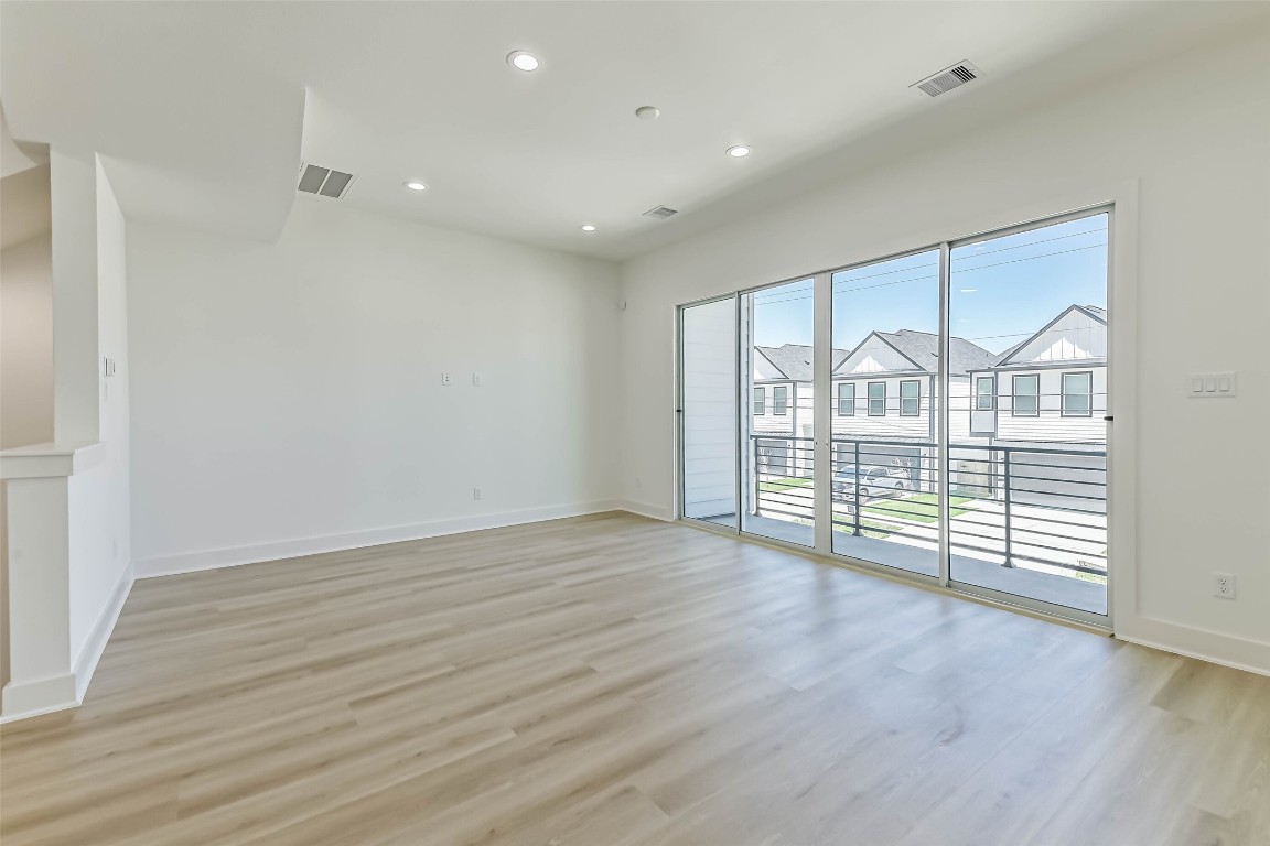 5703 Balbo Street, Unit F Houston, TX 77091 - Photo 11 of 39 wooden floor in an empty room with a window