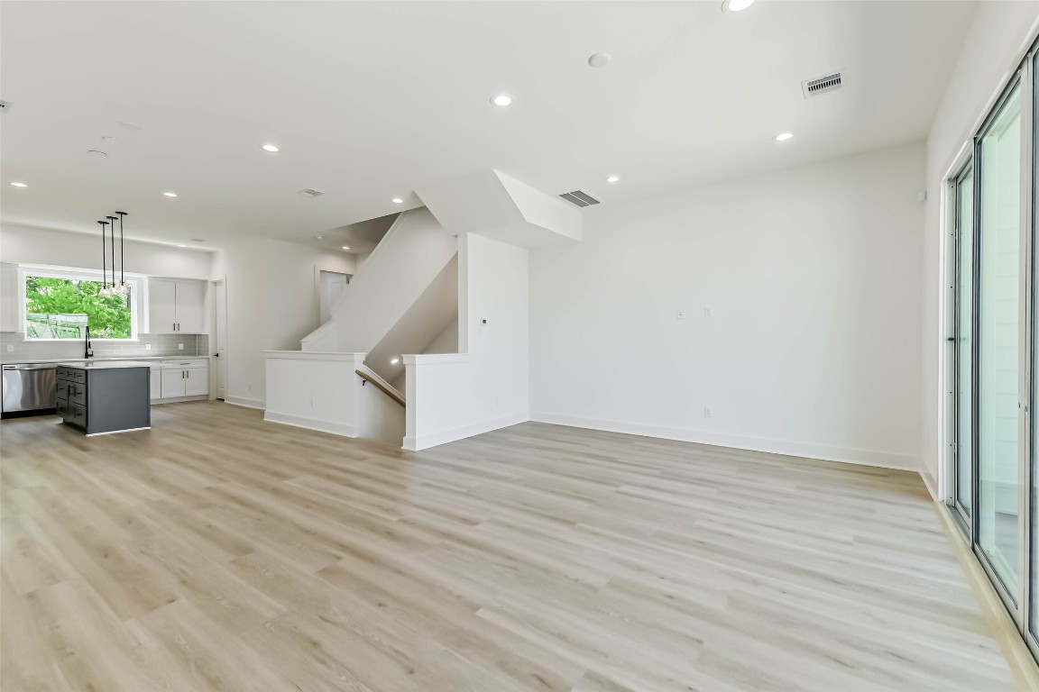5703 Balbo Street, Unit F Houston, TX 77091 - Photo 12 of 39 a view of an empty room with wooden floor and a kitchen