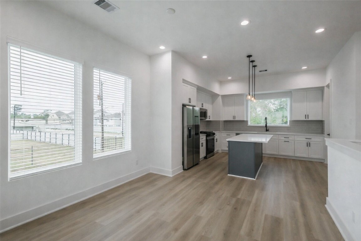 5703 Balbo Street, Unit F Houston, TX 77091 - Photo 17 of 39 a large kitchen with stainless steel appliances kitchen island a large counter top and a sink