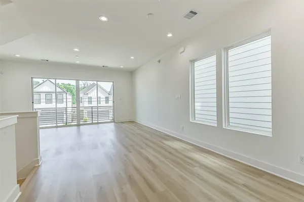 a view of a living room kitchen with furniture and wooden floor