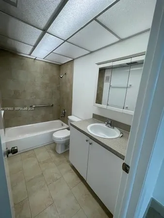 a bathroom with a granite countertop sink a toilet and shower