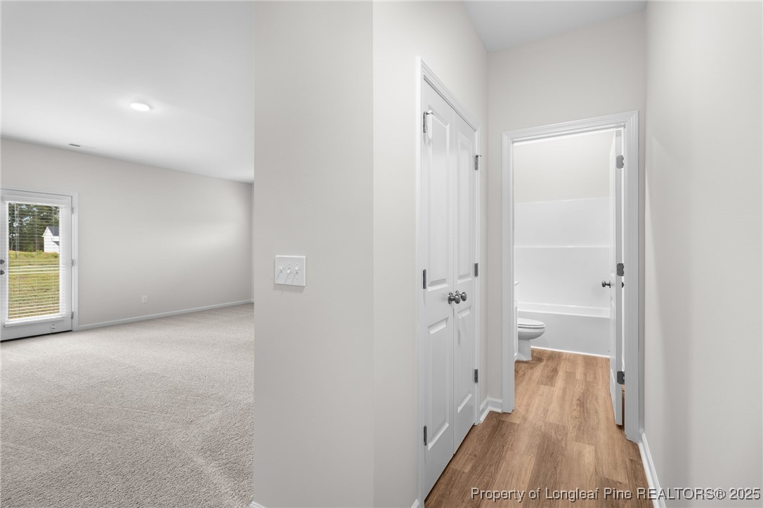 501 Traveller Way Raeford, NC 28376 - Photo 11 of 49 a view of a hallway with wooden floor and a bathroom