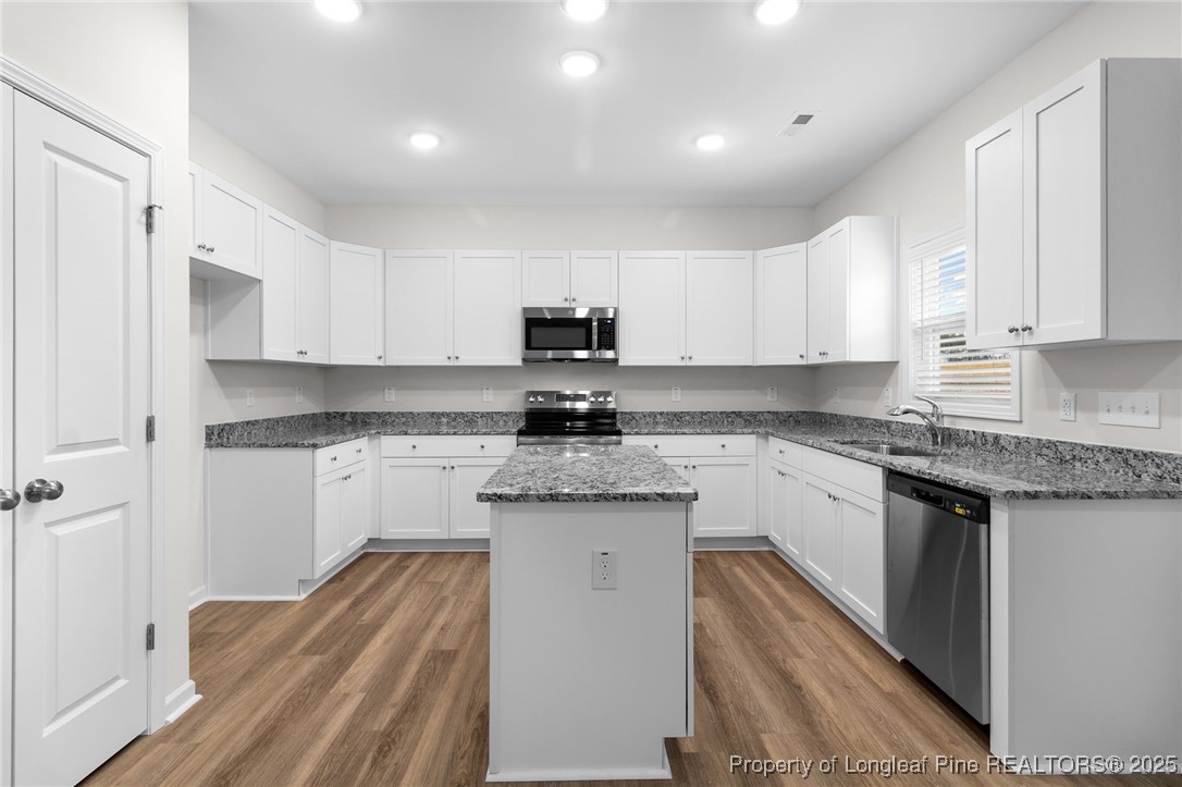 501 Traveller Way Raeford, NC 28376 - Photo 18 of 49 a kitchen with granite countertop white cabinets sink and stainless steel appliances