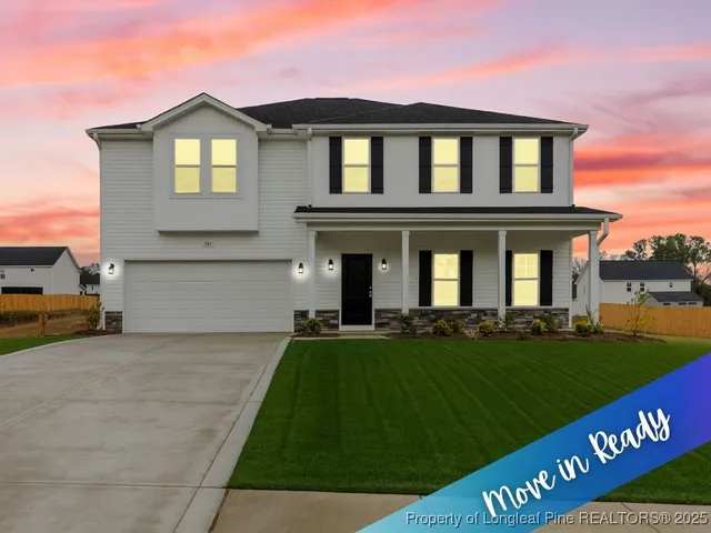 a view of a house with a yard and a large tree