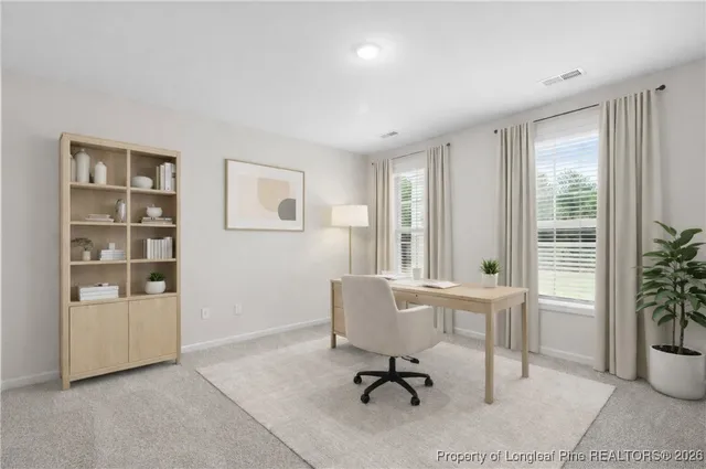 a view of a workspace with furniture and a window