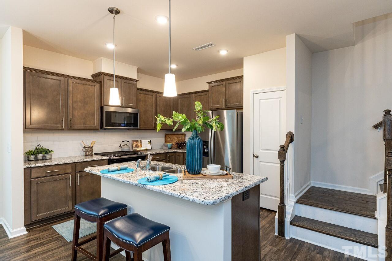 117 Lafferty Street Durham, NC 27560 - Photo 8 of 43 a kitchen with kitchen island granite countertop a sink and appliances