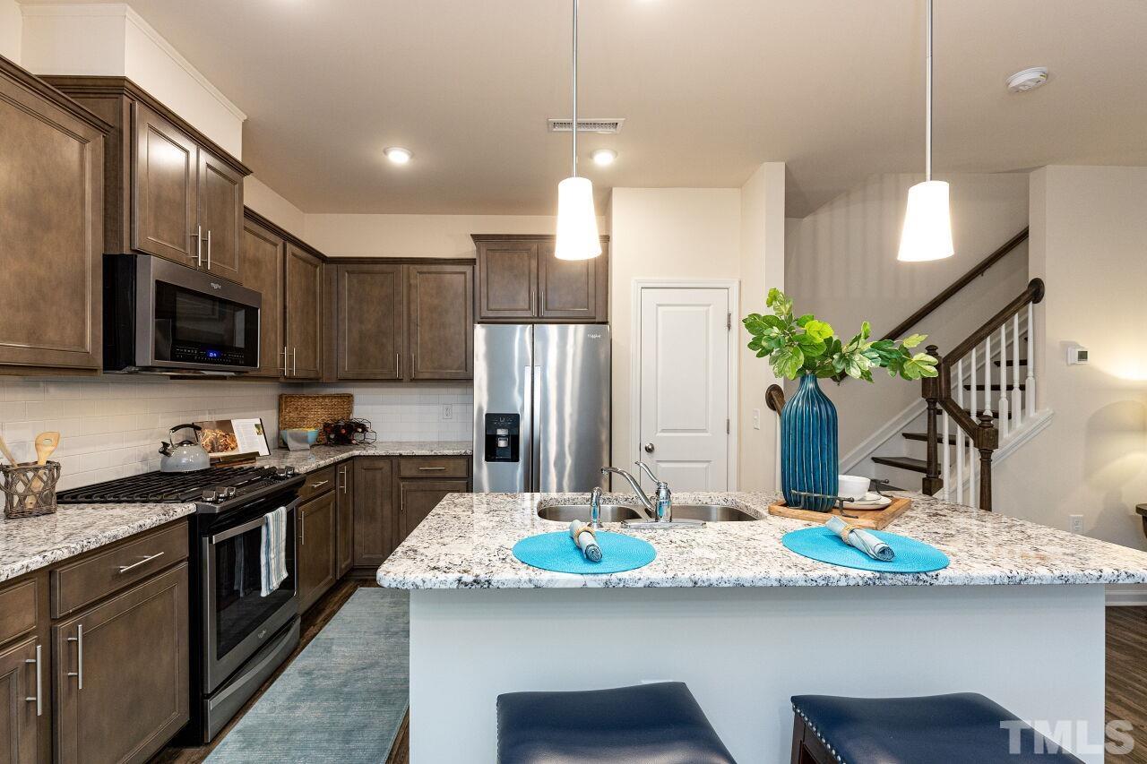 117 Lafferty Street Durham, NC 27560 - Photo 9 of 43 a kitchen with kitchen island granite countertop a sink and refrigerator