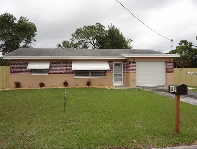 a front view of house with yard and trees