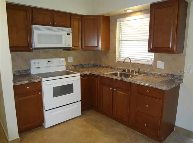 a kitchen with granite countertop a sink cabinets and window