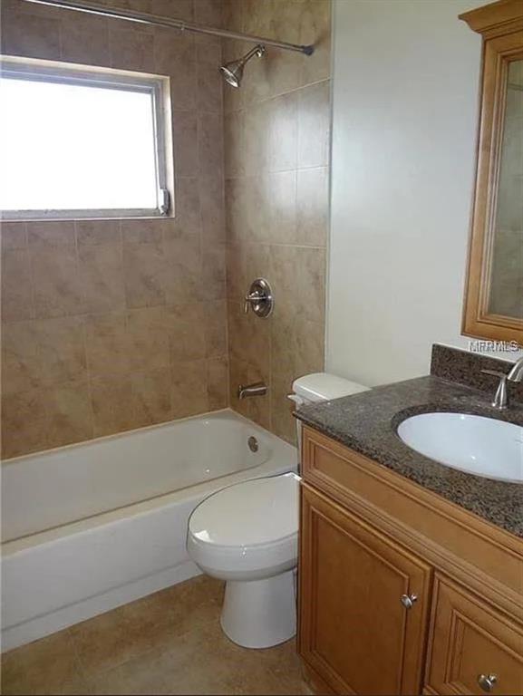 6439 Polk Street New Port Richey, FL 34653 - Photo 8 of 11 a bathroom with a granite countertop toilet a sink and bathtub