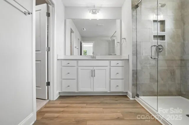 a view of a bathroom with mirror and shower