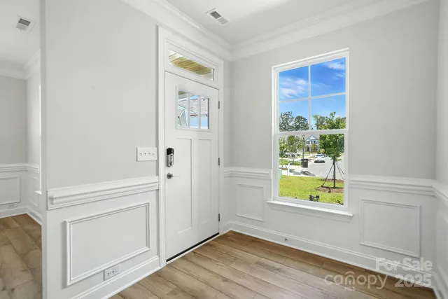 an entryway with wooden floor and windows