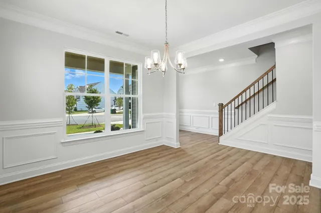 a view of an empty room with wooden floor floors and a window