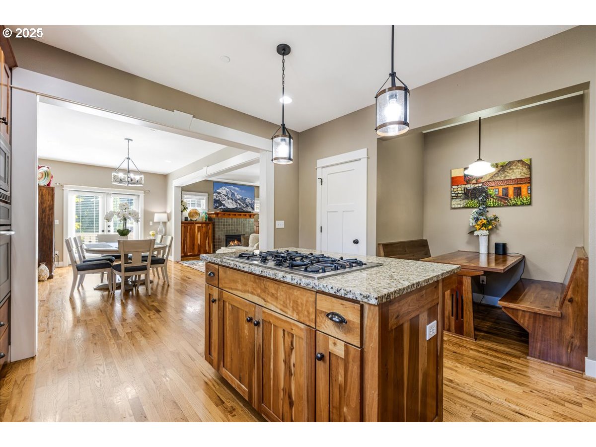 8250 Southwest Indigo Terrace Beaverton, OR 97007 - Photo 17 of 46 a open kitchen with stainless steel appliances granite countertop a stove oven a dining table and chairs with wooden floor