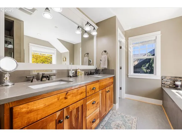 a bathroom with a granite countertop sink mirror and a bathtub