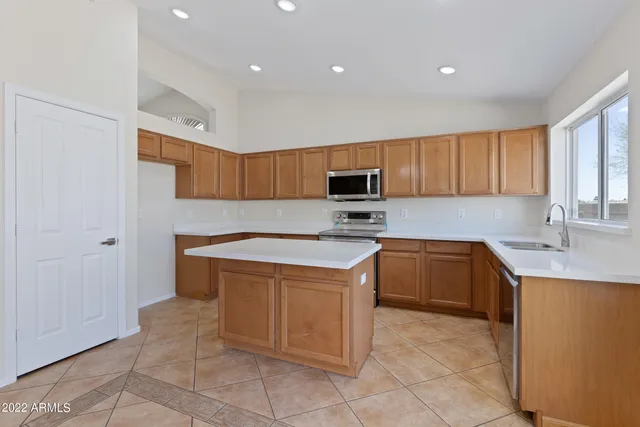 a kitchen with stainless steel appliances granite countertop a stove microwave and sink