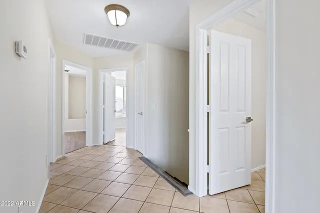 an empty room with wooden floor chandelier fan and windows