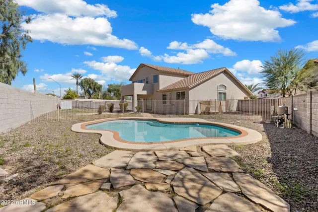 a view of a white house with a large tree