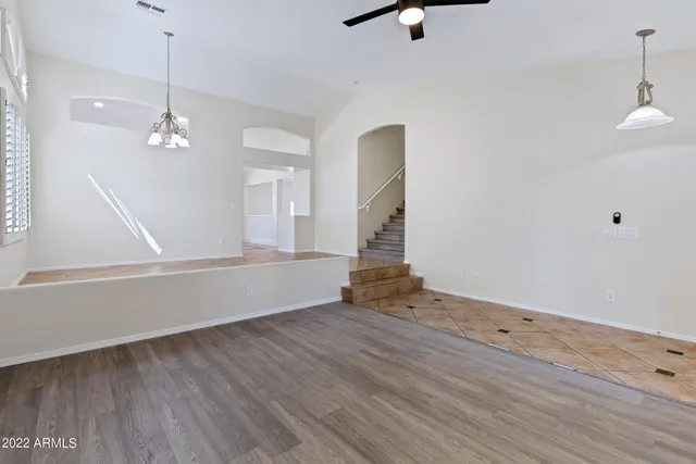 a large kitchen with kitchen island granite countertop a stove top oven a sink dishwasher a dining table and chairs with wooden floor