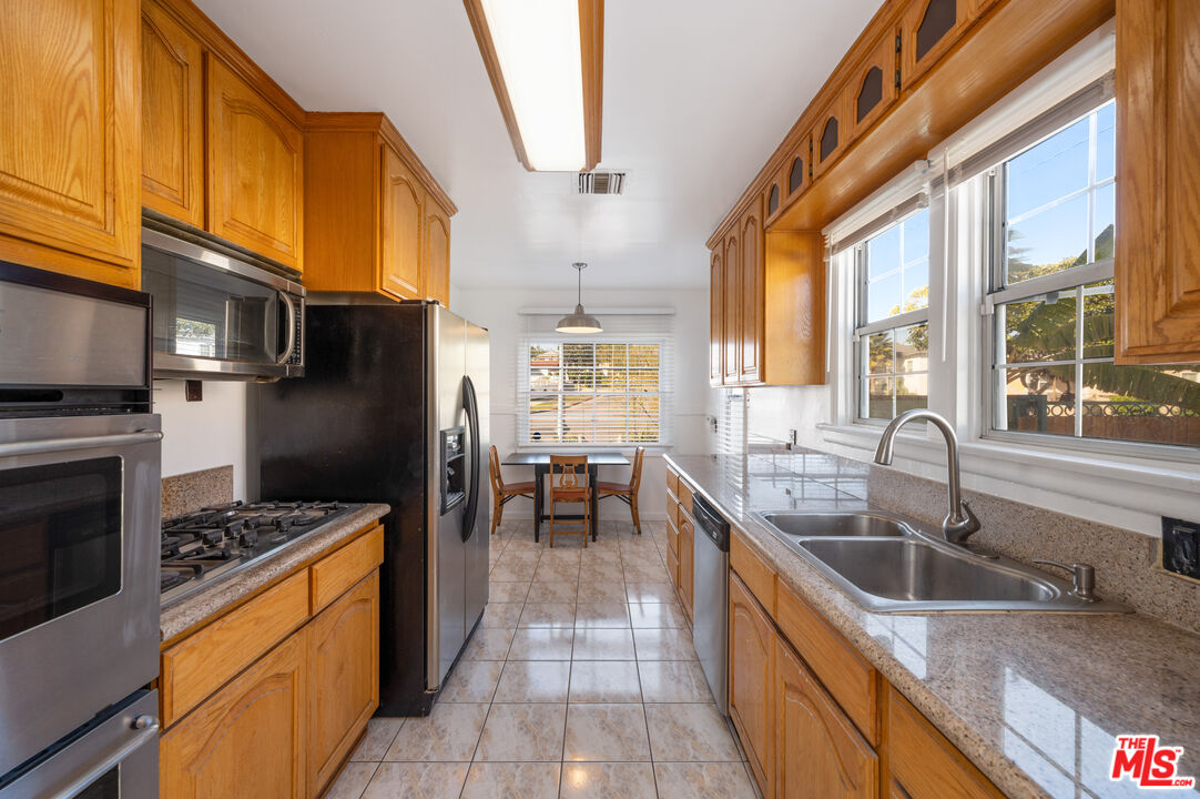 318 East Fairview Boulevard Inglewood, CA 90302 - Photo 12 of 45 a kitchen with stainless steel appliances granite countertop a sink a stove and a refrigerator