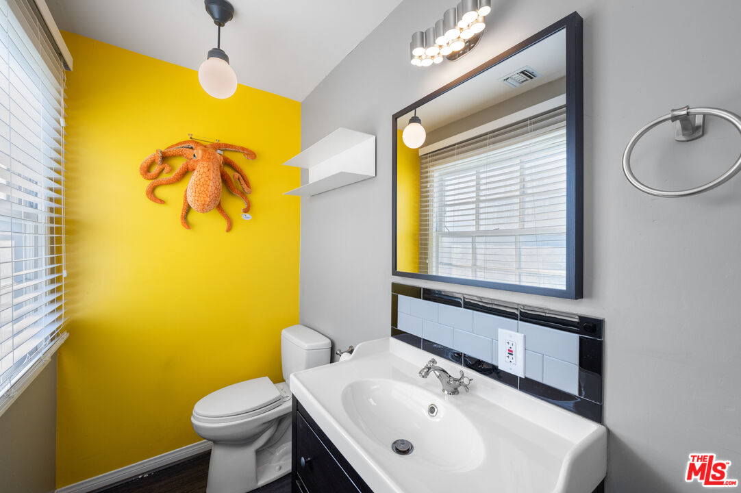 318 East Fairview Boulevard Inglewood, CA 90302 - Photo 23 of 45 a bathroom with a sink mirror and a toilet