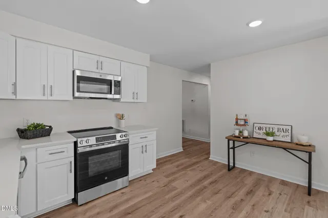 a kitchen with stainless steel appliances a sink cabinets and wooden floor