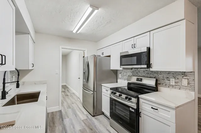 a kitchen with a sink stove and refrigerator