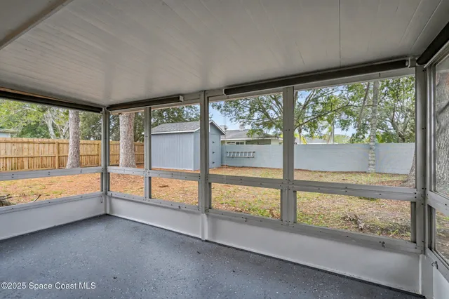 a view of an empty room with large windows