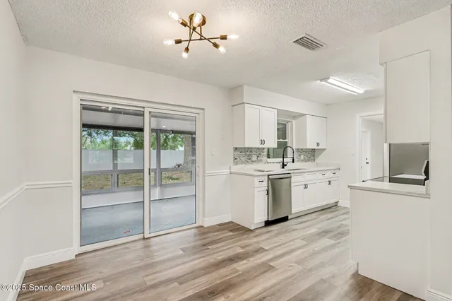 a kitchen with a refrigerator and white cabinets