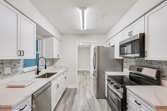 a kitchen with stainless steel appliances a sink stove and refrigerator