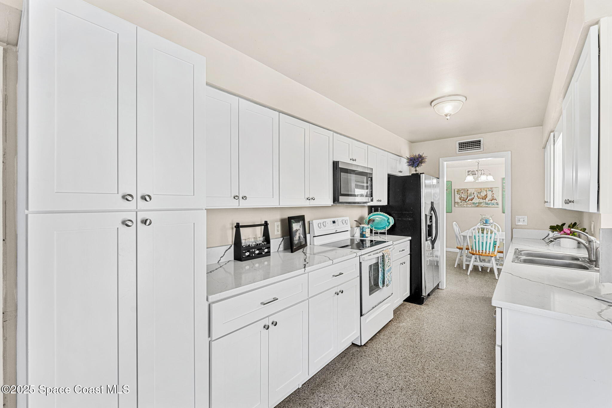 141 Diane Circle Indialantic, FL 32903 - Photo 12 of 36 a kitchen with white cabinets and white appliances