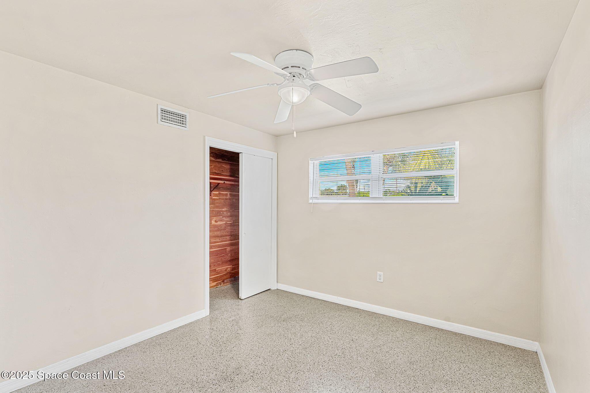 141 Diane Circle Indialantic, FL 32903 - Photo 16 of 36 an empty room with a ceiling fan and a window