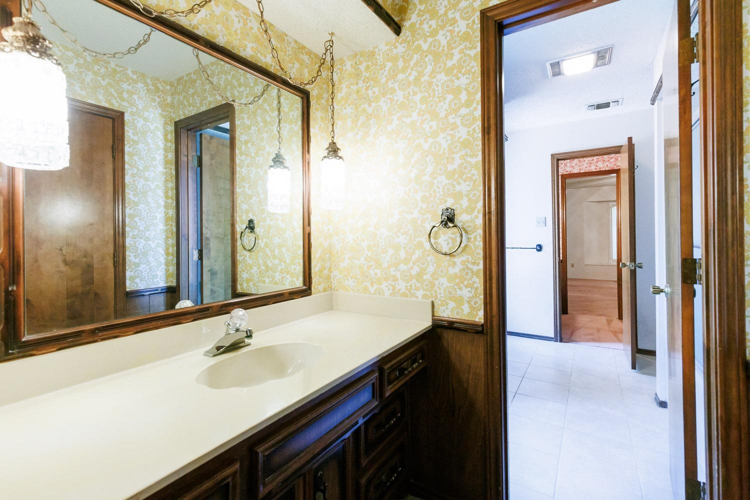 3402 79th Street Lubbock, TX 79423 - Photo 32 of 49 a bathroom with a sink and a mirror