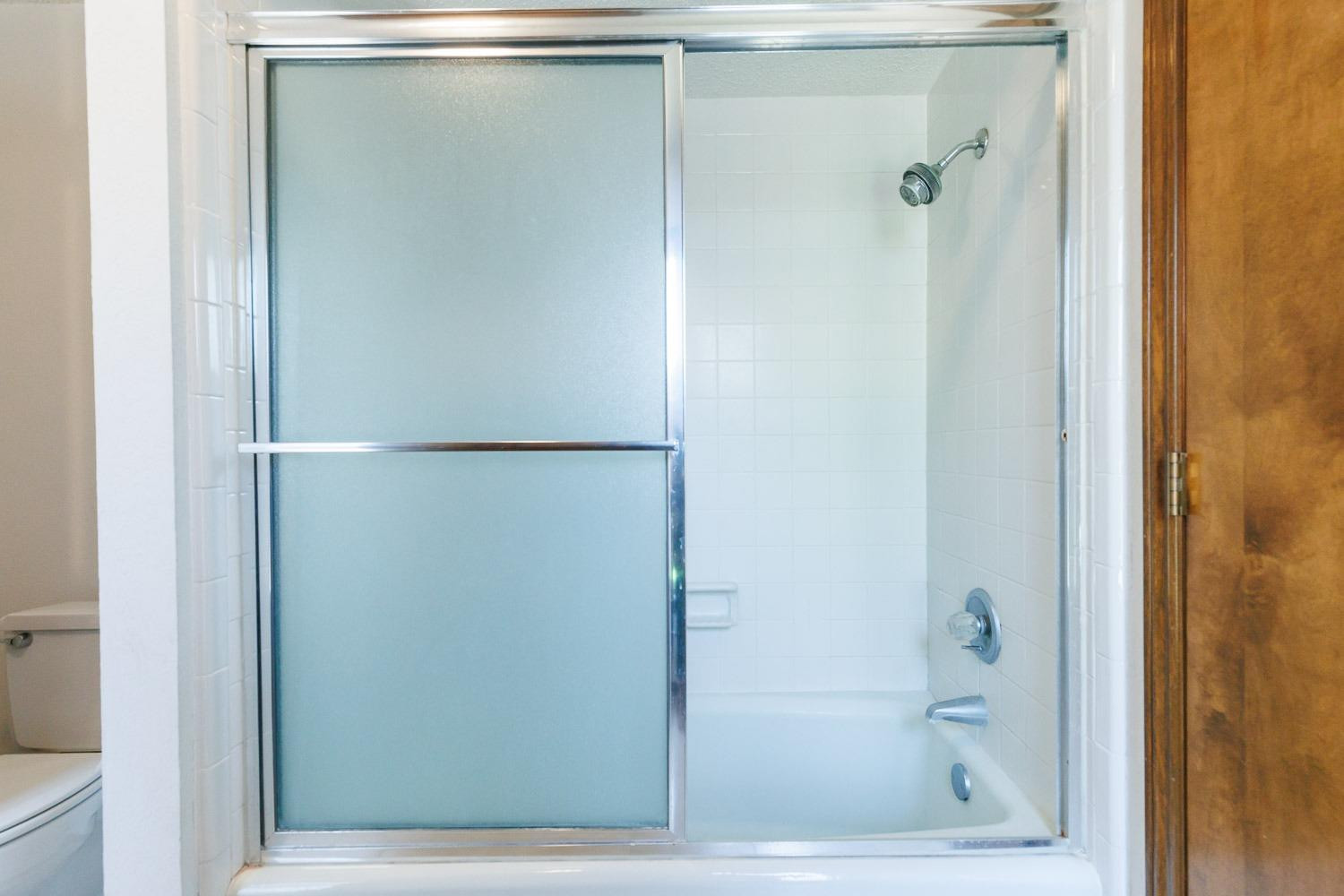 3402 79th Street Lubbock, TX 79423 - Photo 33 of 49 a bathroom with a glass shower door