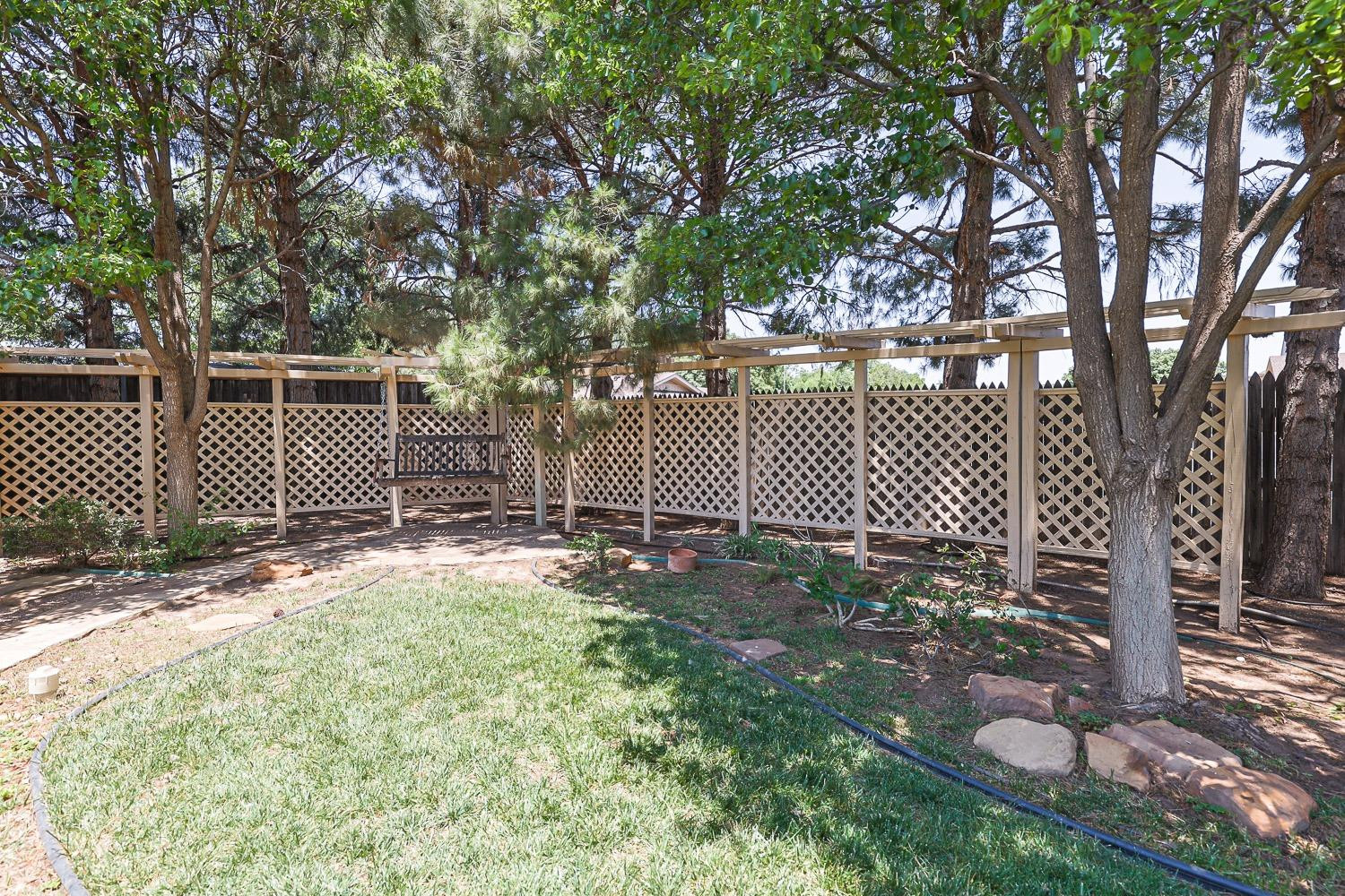 3402 79th Street Lubbock, TX 79423 - Photo 46 of 49 a view of a yard with plants and wooden fence