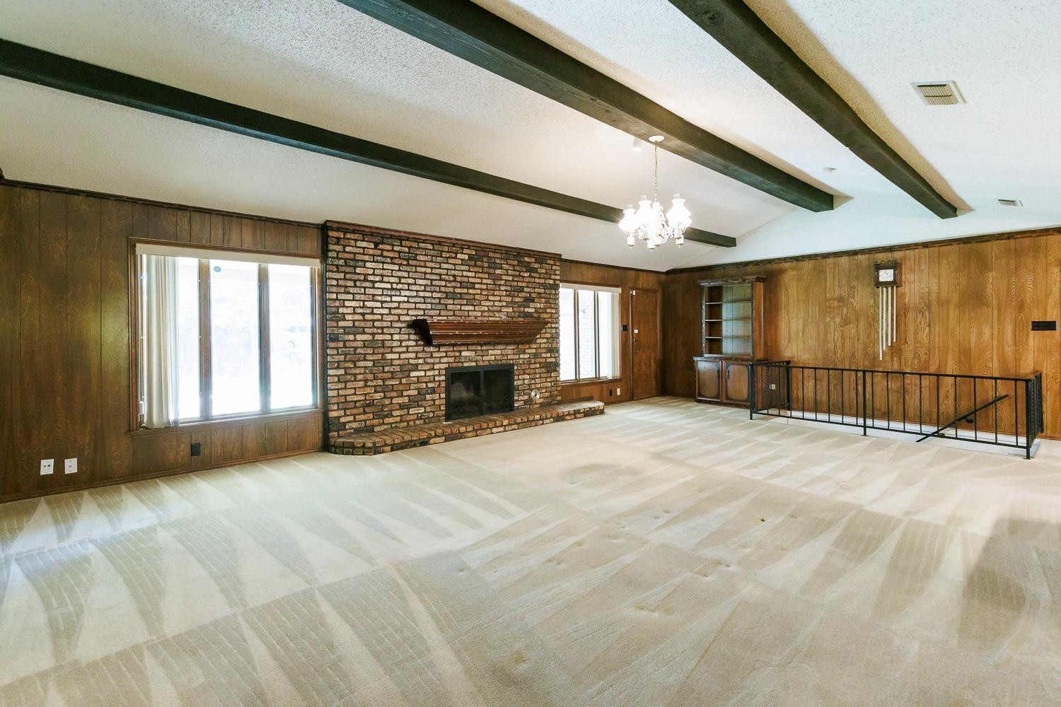 3402 79th Street Lubbock, TX 79423 - Photo 6 of 49 a view of an empty room with a fireplace and a window