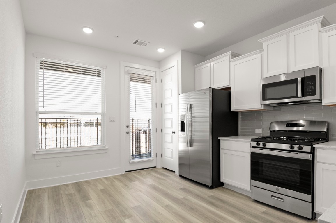 18909 Schultz Lane, Unit 1002 Round Rock, TX 78664 - Photo 10 of 24 a kitchen with stainless steel appliances a refrigerator microwave and stove