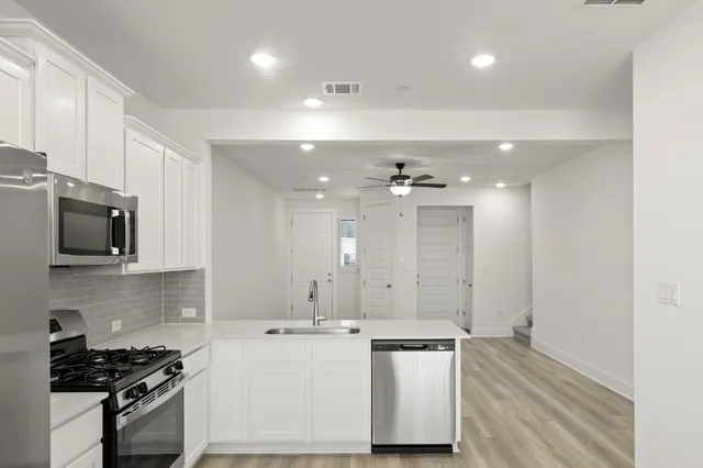 a kitchen with stainless steel appliances a refrigerator sink and microwave