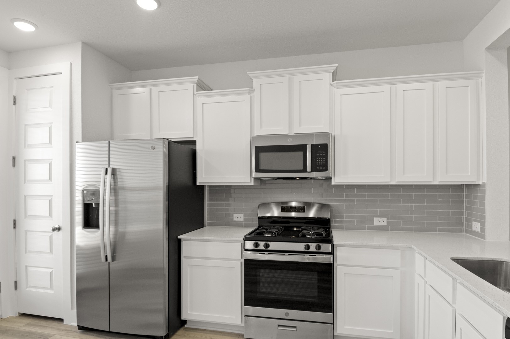 18909 Schultz Lane, Unit 1002 Round Rock, TX 78664 - Photo 16 of 24 Kitchen featuring appliances with stainless steel finishes, white cabinetry, light stone countertops, tasteful backsplash, and recessed lighting