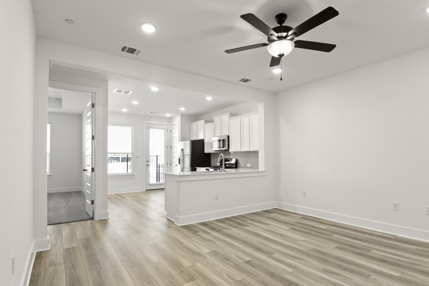 18909 Schultz Lane, Unit 1002 Round Rock, TX 78664 - Photo 24 of 24 Kitchen featuring white cabinets, light wood-type flooring, a peninsula, open floor plan, and recessed lighting