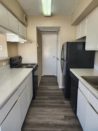a kitchen with stainless steel appliances granite countertop a sink a stove and a wooden floors