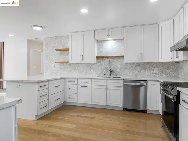 a kitchen with granite countertop white cabinets white stainless steel appliances with a sink and dishwasher