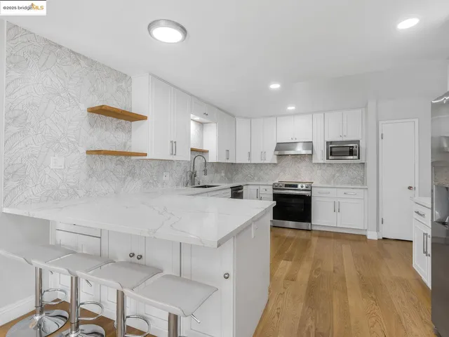a kitchen with a sink a counter top space stainless steel appliances and cabinets
