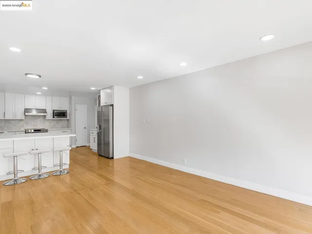 a view of kitchen with granite countertop cabinets and refrigerator
