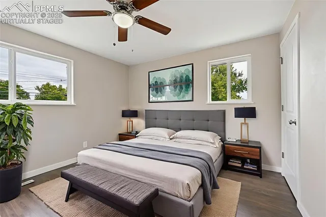 an empty room with wooden floor cabinet and windows