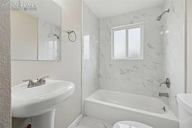 a bathroom with a toilet a sink and bathtub