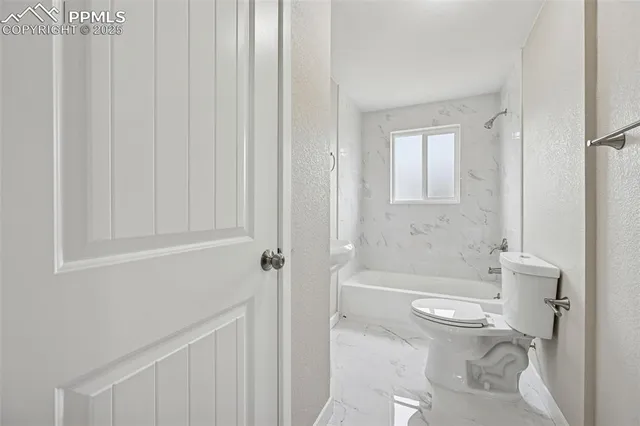 a view of an empty room with a window and a ceiling fan